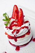 Dessert of strawberry meringue with a cream and strawberry coulis