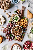 A bowl of spicy candied pecans, cheese and fruit board