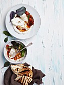 Poached eggs on harissa with stewed tomatoes and grilled flatbread