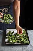 Making kale chips, female hands placing cabbage leaves on a tray