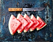 Watermelon slices and ice on blue background