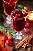 Hot mulled wine with small crab apples, cinnamon stick ans anise closeup
