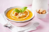 Pumpkin soup with croutons, cream and basil