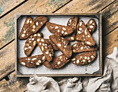 Dark chocolate and sea salt Biscotti with almonds in wooden tray over rustic wooden background