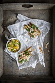 Asparagus satay and peanut dip served on sandwich paper and grey vintage tray