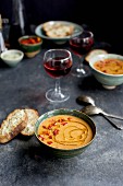 Tomatenpesto-Suppe mit Bohnen und Chiliöl dazu Asiago-Crostini und Rotwein