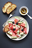 Watermelon salad with feta cheese, black olives, onion and basil
