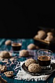 Tahini-Kekse zum Espresso im Glas auf Vintage-Holztisch