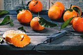Tangerines with leaves and vintage steelyard on old wooden table