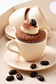 Cappuccino-Cupcake in Espressotasse mit Schokoladenbohnen