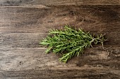 Bunch of rosemary stems tied with string on a wooden surface