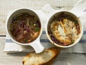 Two bowls of onion soup with and without grilled cheese croutons