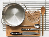 Various kitchen utensils: pot, measuring cup, knives, spoon