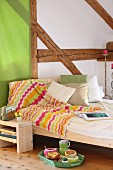 Crocheted blanket with zigzag pattern draped over bed in half-timbered room