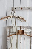 Old clothes hangers and tape measure hung from peg and from shutter