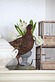 Arrangement of stuffed pheasant next to hyacinths and cages
