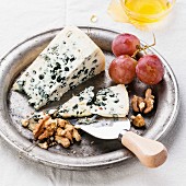 Dor Blue Cheese with honey, nuts and grapes on plate