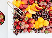 White plate with fruits and berries on table outdoor