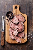 Roast beef on cutting board with salt and pepper