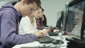 Teenagers working on computer in technology class