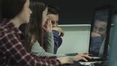 Teenagers working on computer in technology class
