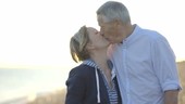 Portrait of Retired Senior Couple kissing on the beach