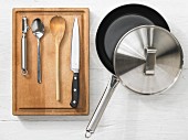 Various kitchen utensils: pan, peeler, spoon, knife