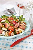 Salad with couscous, strawberries, cheese, bread croutons, lettuce, hazelnuts and ham