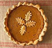 Homemade pumpkin pie with pastry elm leaves