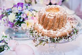 Festively decorated bundt cake on cake stand and centrepiece on Easter table