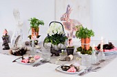 Decorative flower arrangements and rabbit figurines on festively set Easter table