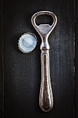 An antique bottle opener and bottle top
