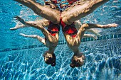 Two synchronised swimmers upside down in the water