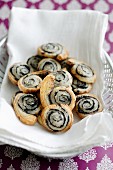 Poppyseed and puff pastry swirls on white linen napkin