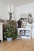 Christmas tree in zinc tub next to arrangement of vintage items