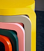 Legs of stacked nest of tables in bright, plain colours