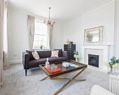 An elegant living area with an upholstered couch and a coffee table in front of a gas fireplace