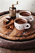 Hot chocolate sprinkled with white chocolate and spices on dark wooden background