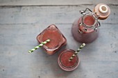 Strawberry Smoothies in jars with stripy straws