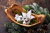 Christmas decorations Bells in olive wood bowl on green fir branches background