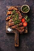 Sliced medium rare grilled beef barbecue Sirloin steak with chimichurri sauce on cutting board