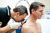 Dermatologist examining patient