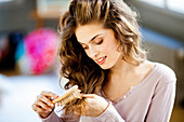 Woman inspecting the tip of her hair