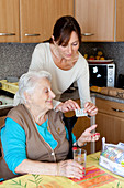 Woman assisting elderly woman