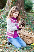 Girl picking up pine cones