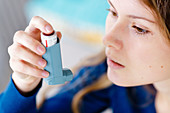 Woman using an aerosol inhaler