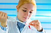Young woman using pipette
