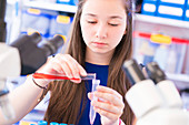 Girl pouring chemical into test tube