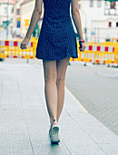 Young woman in short dress walking on pavement