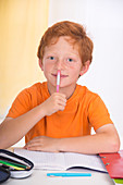 Boy holding pen doing homework